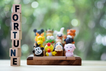 Wood block text with fortune with blur background of animal in the Chinese zodiac.