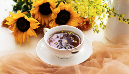 Autumn, fall leaves, flowers hot cup of herbal tea on wooden rustic background. Seasonal, morning tea. Sunday relaxing and still life concept. Toned image.