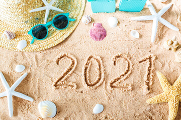 2021 text in the sand with beach accessories
