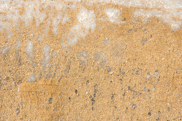 Texture of yellow sand on white ice. Sand is poured onto ice for safe movement, pedestrian care, traffic safety