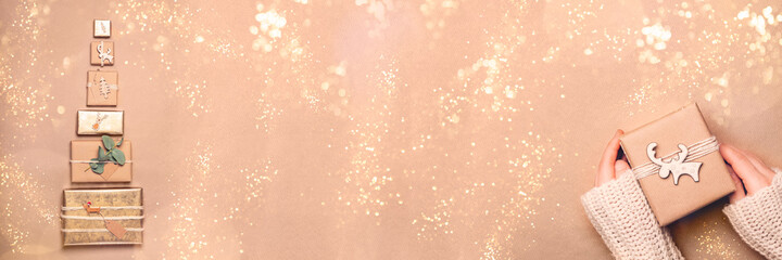 Christmas banner. Gifts wrapped in recycled brown paper with handmade toppers, christmas background with minimalist style wrapping, top view, copy space