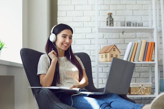 Young woman student attend online class, webinar or internet lecture from home using laptop computer