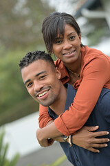 Portrait of happy mixed raced couple standing outside the house