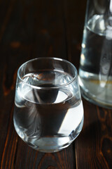 Glass of water on wooden table, closeup. Refreshing drink
