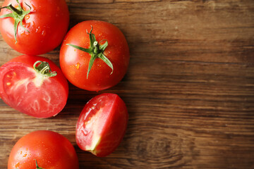 Fototapeta na wymiar Fresh ripe tomatoes on wooden table, flat lay. Space for text