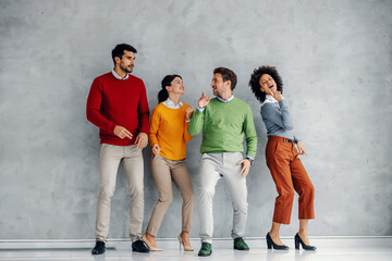 Four cheerful playful successful business people dancing.
