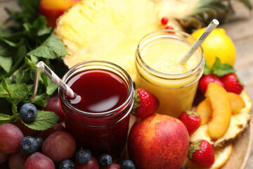 Delicious colorful juices in glasses and fresh ingredients on table, closeup