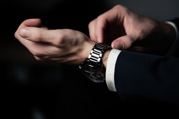 Hand with wrist watch in a business suit close up