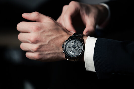 Hand with wrist watch in a business suit close up