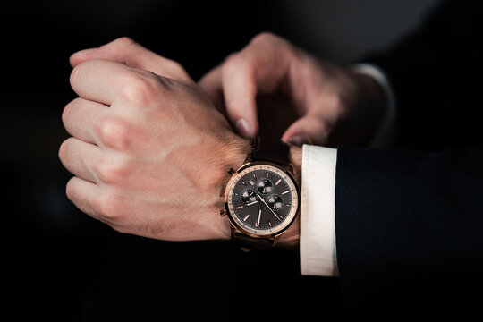 Hand with wrist watch in a business suit close up