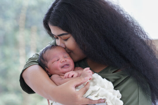 Portrait Of African Mom Carrying And Kiss Adorable Newborn Baby In Her Arm. Happy Lovely African American Family Mother And Son At Bedroom