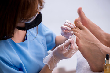 Podiatrist treating feet during procedure