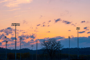 Landscape sunset or sunrise with silhouette of poles or column of spotlight or stadium light in arena with mountain and beautiful sky cloud and with copy space.