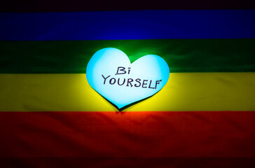 Lgbt community colorful flag. Bi yourself signs on hearts on rainbow background. Lesbian, gay and bisexual problems. Legalization of marriage for couples with homosexual orientation.