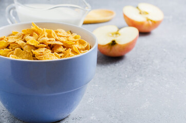 Corn flakes in a blue Cup and Apple slices. Useful Breakfast in the morning. Copy space