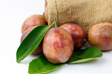 Passion fruit with leaves placed on the grounds and in sackcloth bags isolated on white background