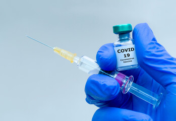 Pharmaceutical research. Coronavirus, Covid 19 Virus Syringe and vaccine vial in human hand with...