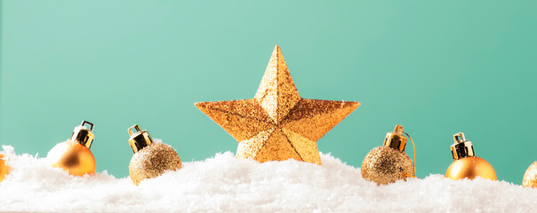 Christmas background with golden star. New Year's decor. Christmas balls in smowdrifts and golden...
