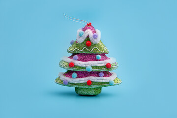 Creative layout with a Christmas tree on a bright blue background. Minimal winter nature holiday...