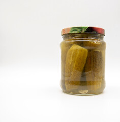 Transparent jar with pickled cucumbers on a white background.