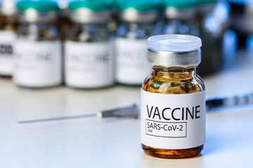 Covid-19 vaccine bottle with a syringe on lab table