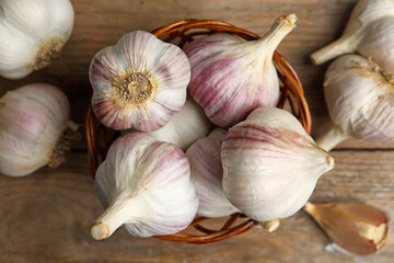 Fresh organic garlic on wooden table, flat lay