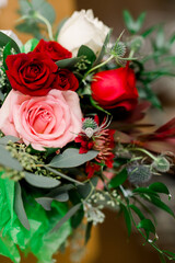 Beautiful flower arrangement with red and pink roses and green leaves