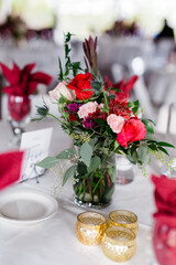 A vase of beautiful flowers with roses in red and pink