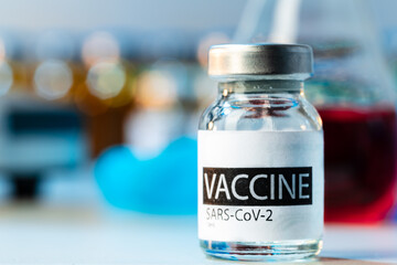 Vaccine vials of Sars-cov-2 on table in laboratory .