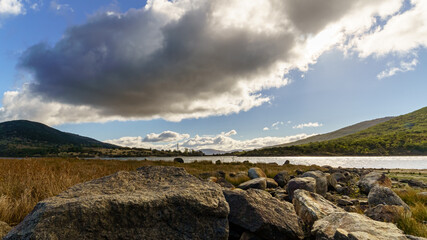 Paisaje dram&aacute;tico con lago, monta&ntilde;as y cielo nublado en Lozoya Madrid.