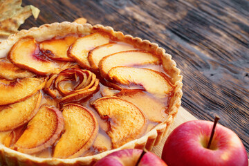 Apple tart pie and red apples on wooden table