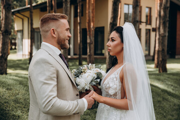 Portrait of the bride and groom. Walk the newlyweds in the open air. Beautiful summer photo session.
