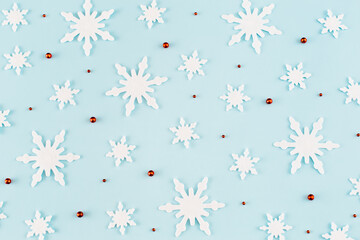 Christmas composition. Pattern made of snowflakes, red decorations on blue background. Christmas, winter, new year concept. Minimal style. Flat lay, top view.