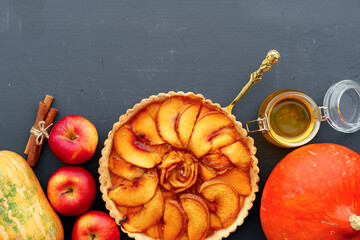 Apple tart pie and red apples on wooden table