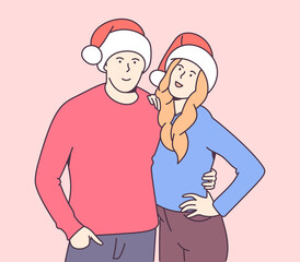 Christmas, gift, New Years eve concept. Happy smiling young couple in christmas hats hugging. Traditional celebration.