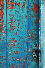 blue and red Peeling paint on old wooden door