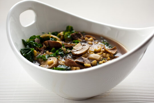 Close up of barley soup with mushrooms and kale