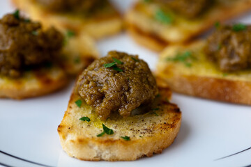Close up of Sicilian pistachio sauce topped on crostini