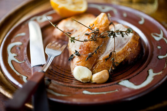 Chicken with thyme and garlic on plate