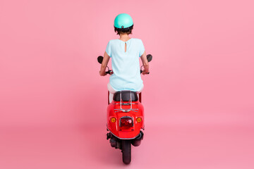 Rear behind view photo of nice pretty girl sitting on moped driving slowly wear blue t-shirt...