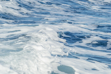 Naklejka na ściany i meble Waves of blue-white foamy sea water 