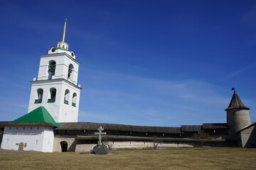 memorial cross and bell tower of the Trinity Cathedral in Pskov Krome. Spring. Russia