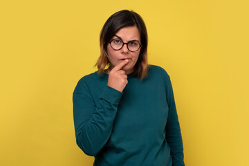 Caucasian woman with glasses having thoughtful look. Pensive female with puzzled expression...