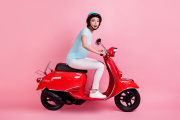 Fototapeta na wymiar Profile photo of impressed young lady ride moped wear white pants shoes blue slam t-shirt isolated on pastel pink background