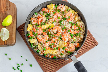Shrimp Fried Rice in a Skillet on a Place Mat Top Down Flat Lay Photo on White Background