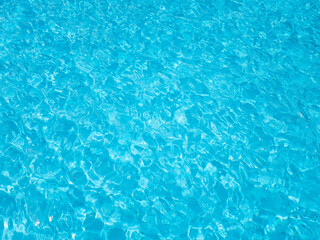 Blue rippled water in swimming pool. Background shot of aqua water surface.