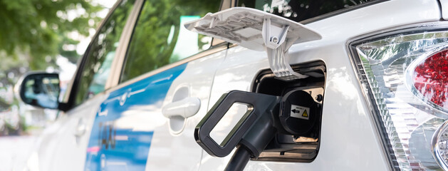 Selective focus at electric taxi car charger plug  while charging battery at the station....