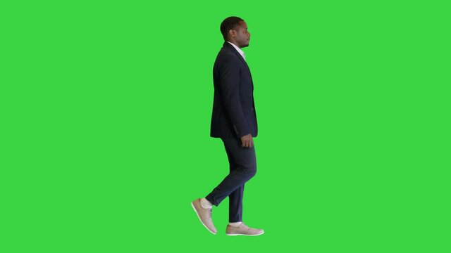 African businessman in formal wear walking on a Green Screen, Chroma Key.