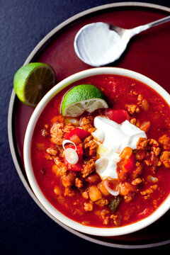 Overhead View Of Hominy Chili With Limes In Bowl