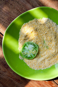 Green tomato and breadcrumbs on green plate